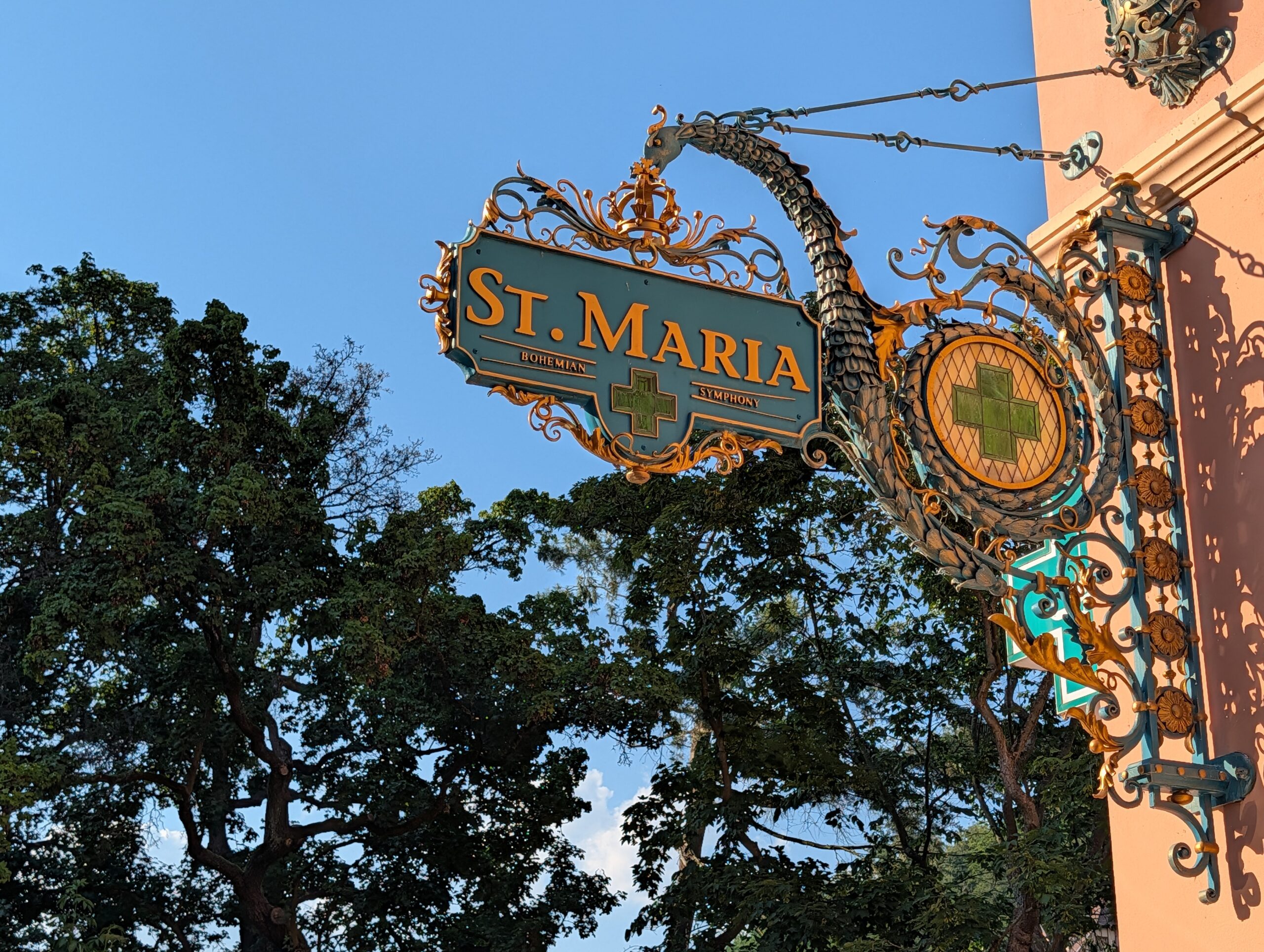 Verziertes Schild der St.-Maria-Apotheke mit grünen Apothekenkreuzen in Karlsbad
