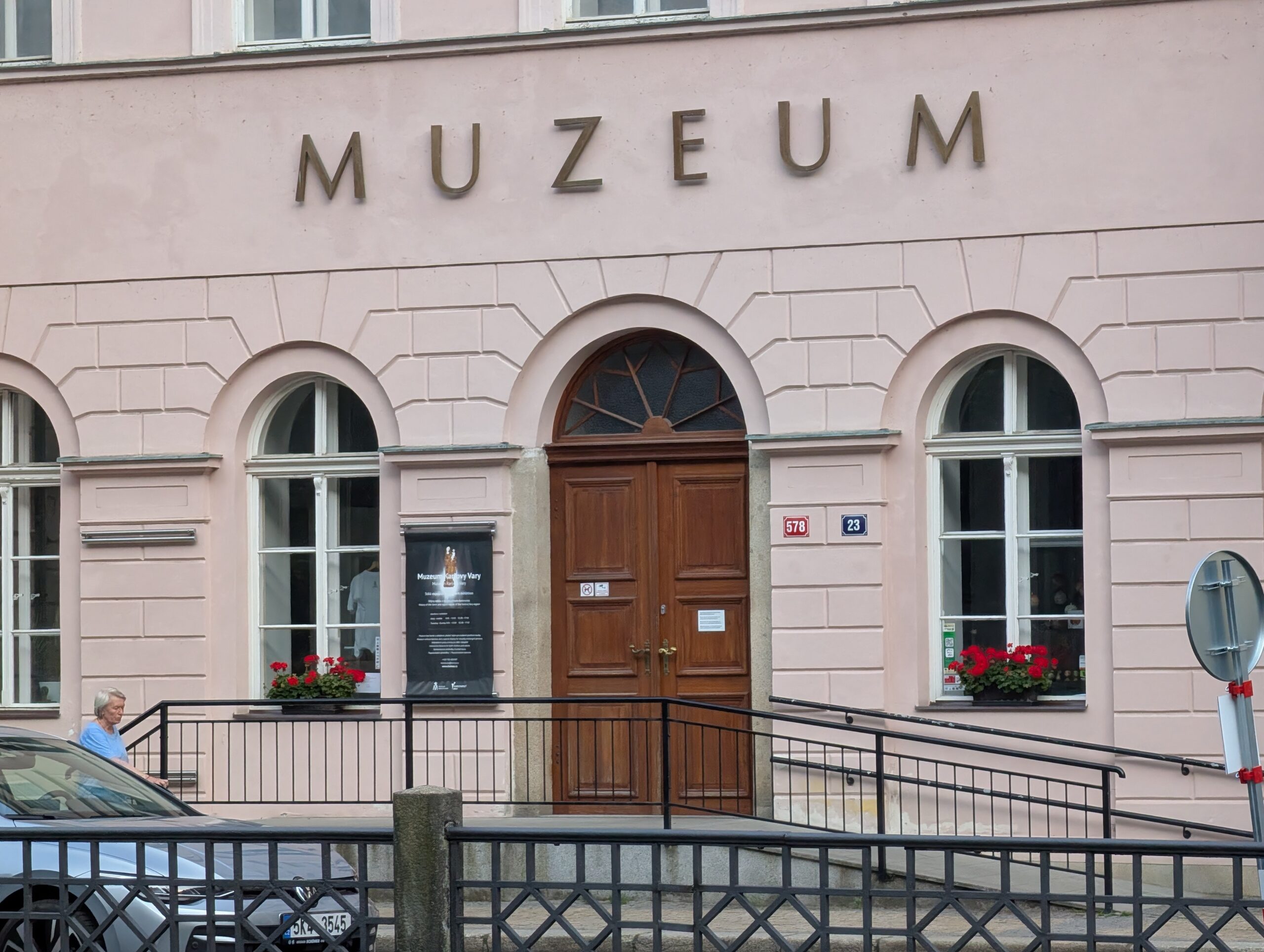 Eingang des Museums Karlsbad mit Rundbogenfenstern, Holztür und Schriftzug „Muzeum“