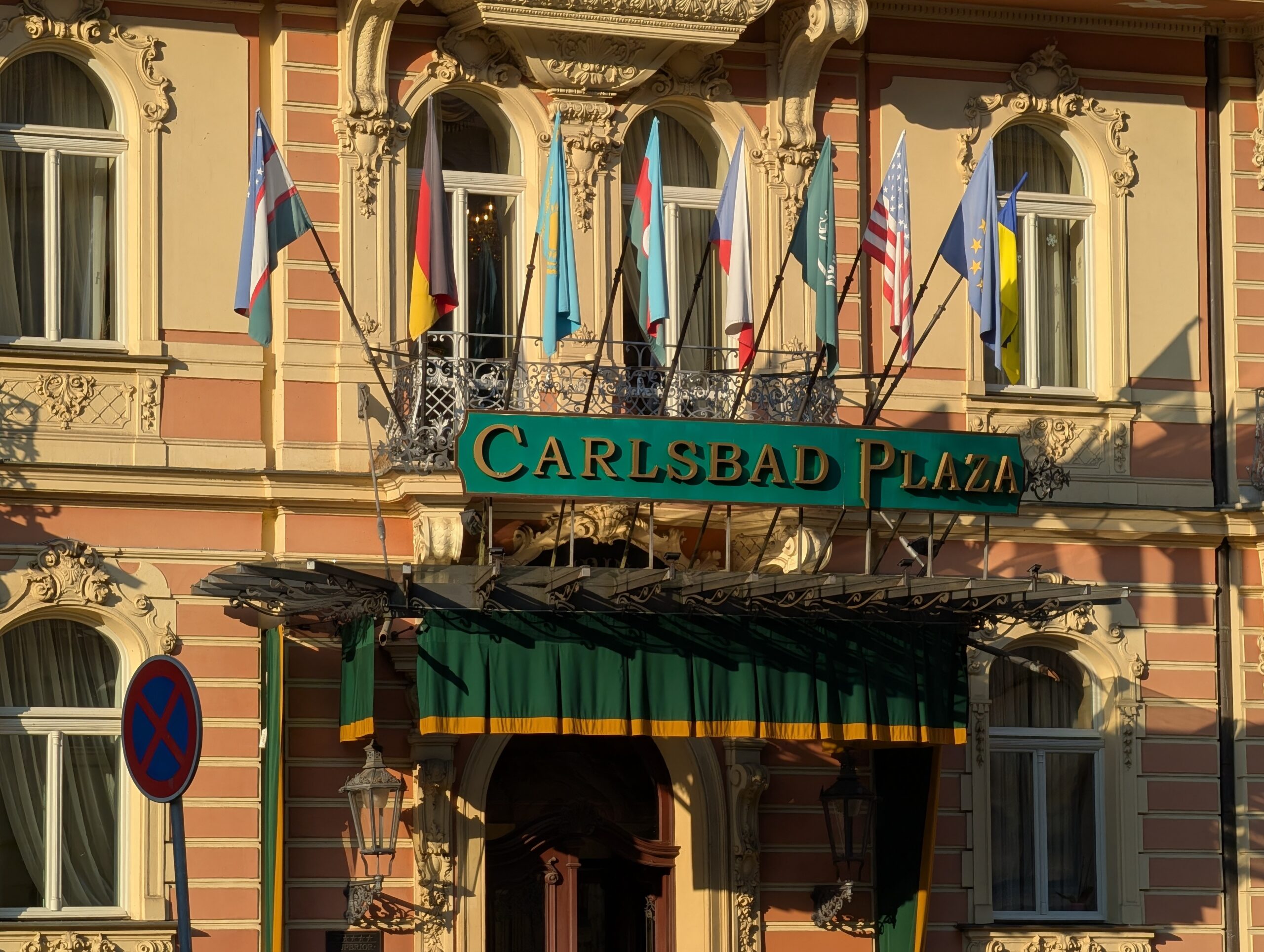 Eingang des Carlsbad Plaza mit internationaler Beflaggung und verzierter Fassade in Karlsbad