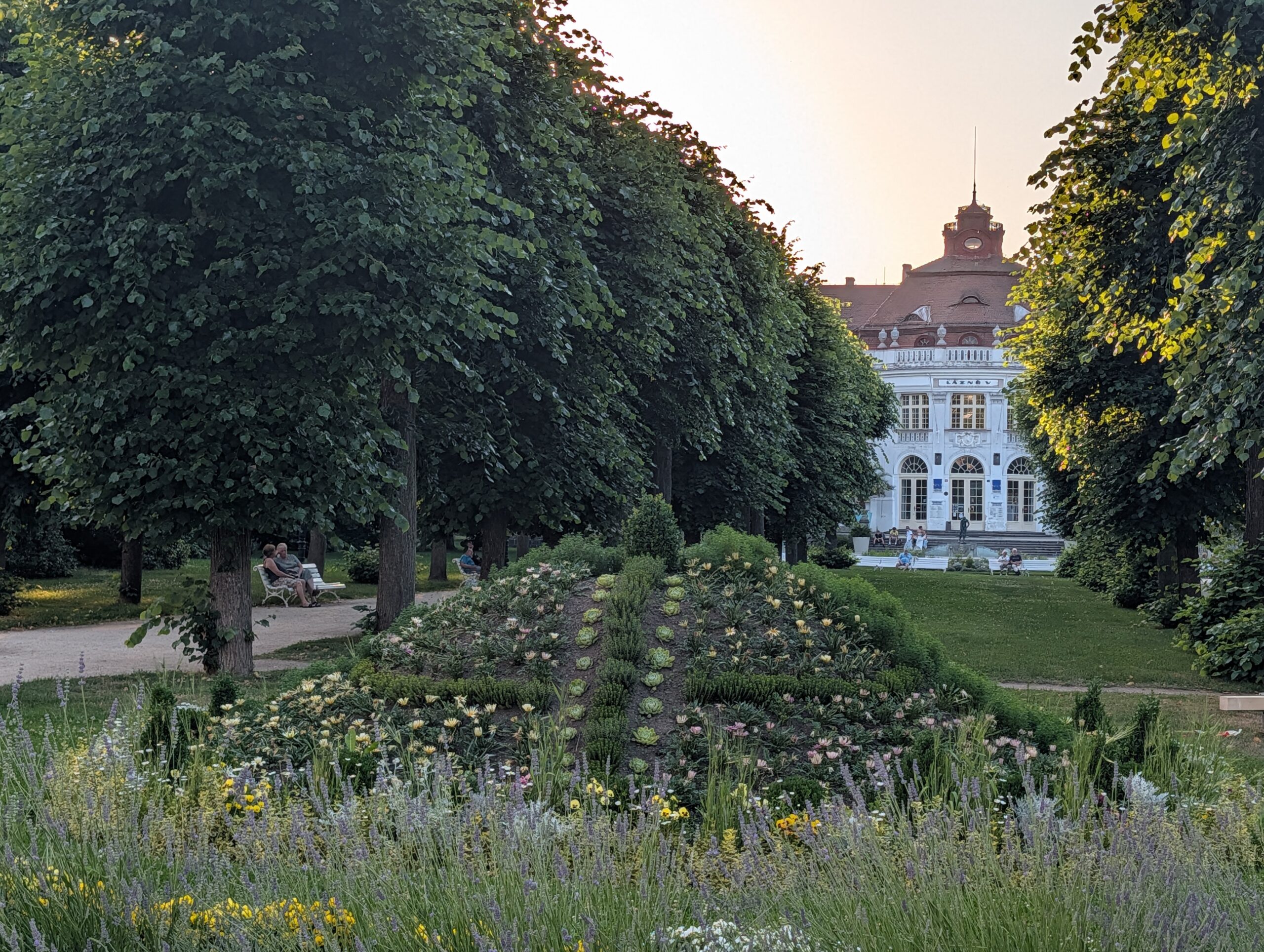 Blumenbeete und Baumreihen im Smetana-Park mit dem Elisabethbad im Hintergrund