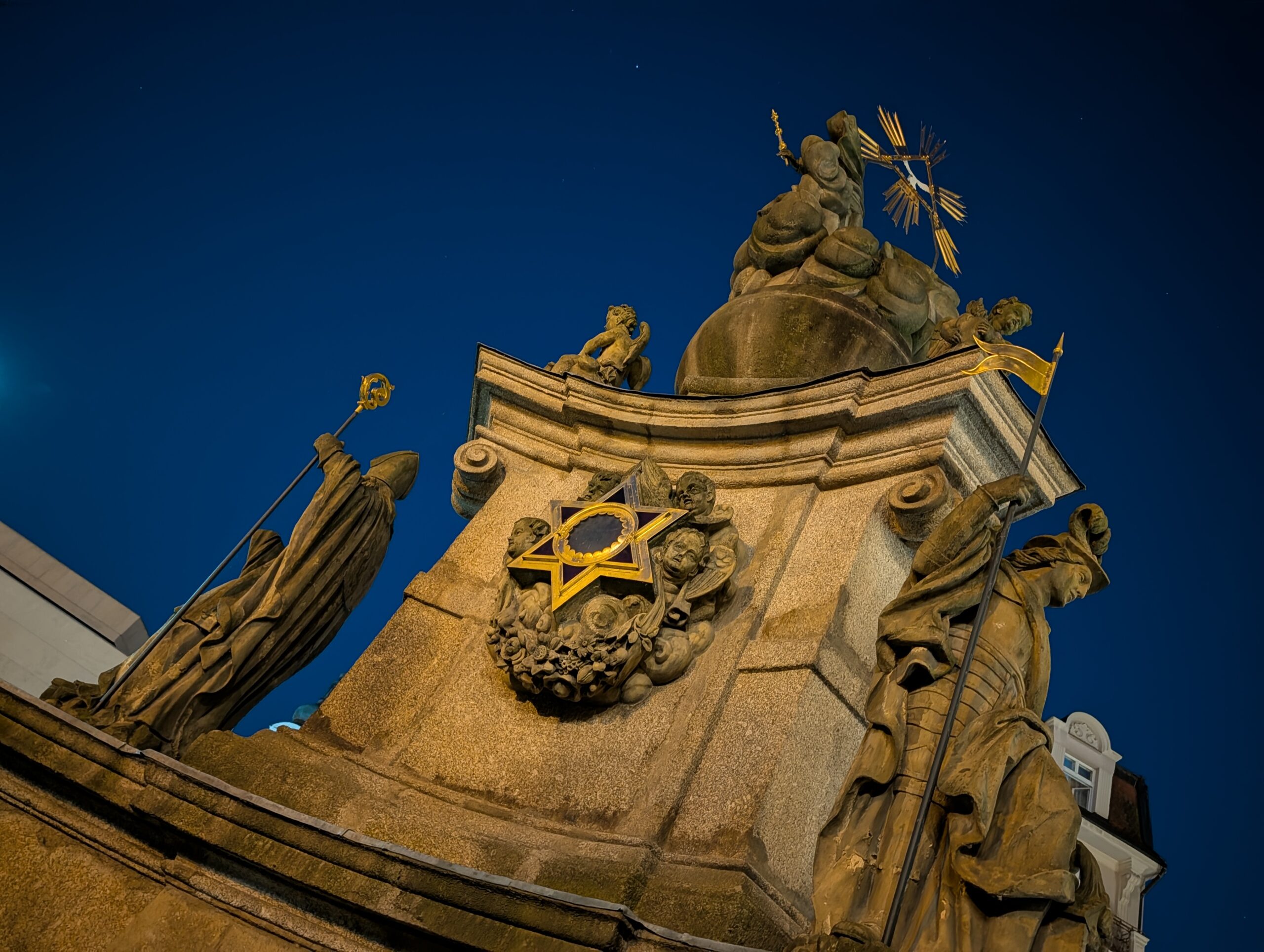 Beleuchtete Dreifaltigkeitssäule mit Heiligenfiguren in Karlsbad