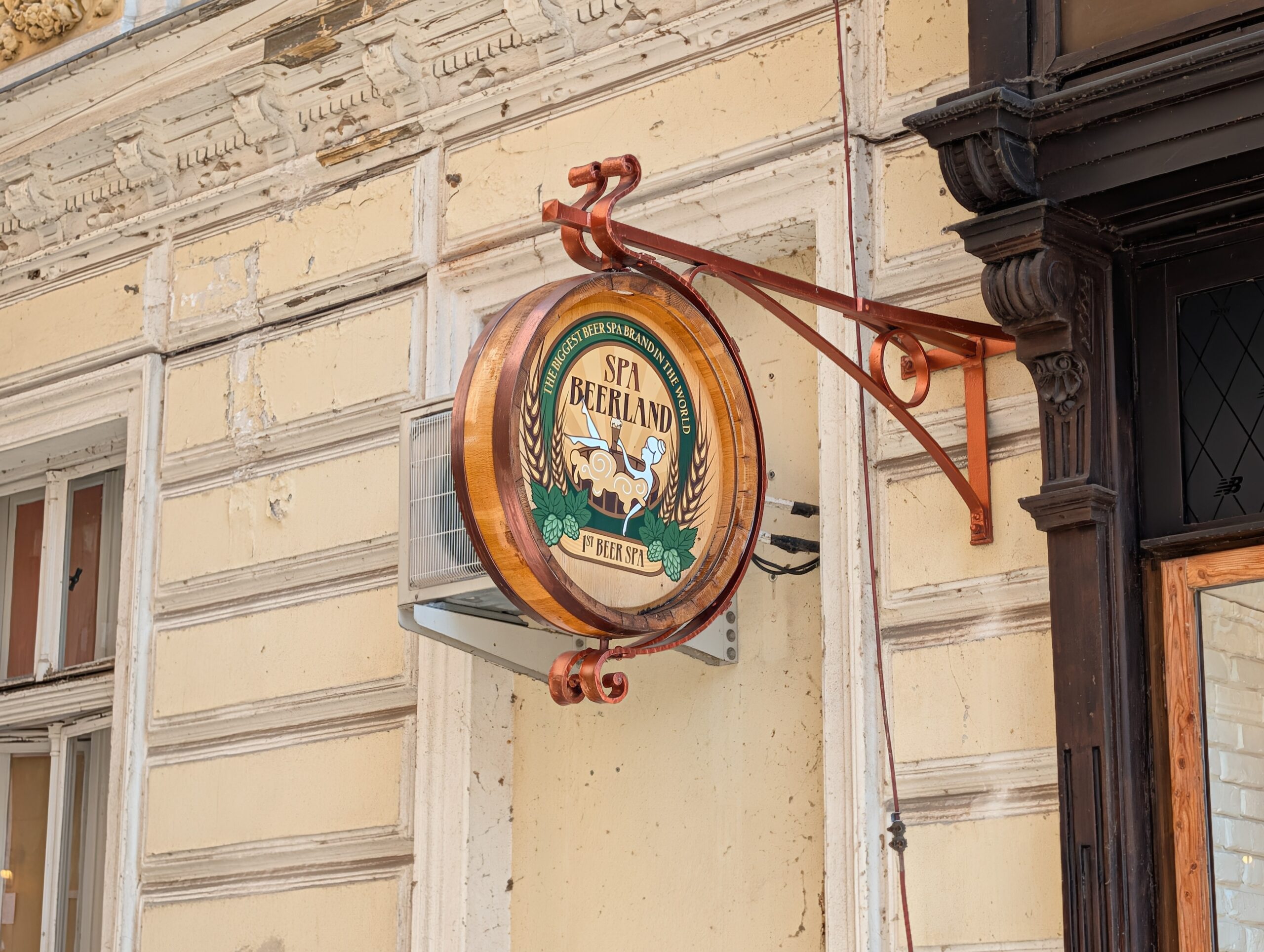 Rundes Spa-Beerland-Schild an einer historischen Hausfassade in Karlsbad.