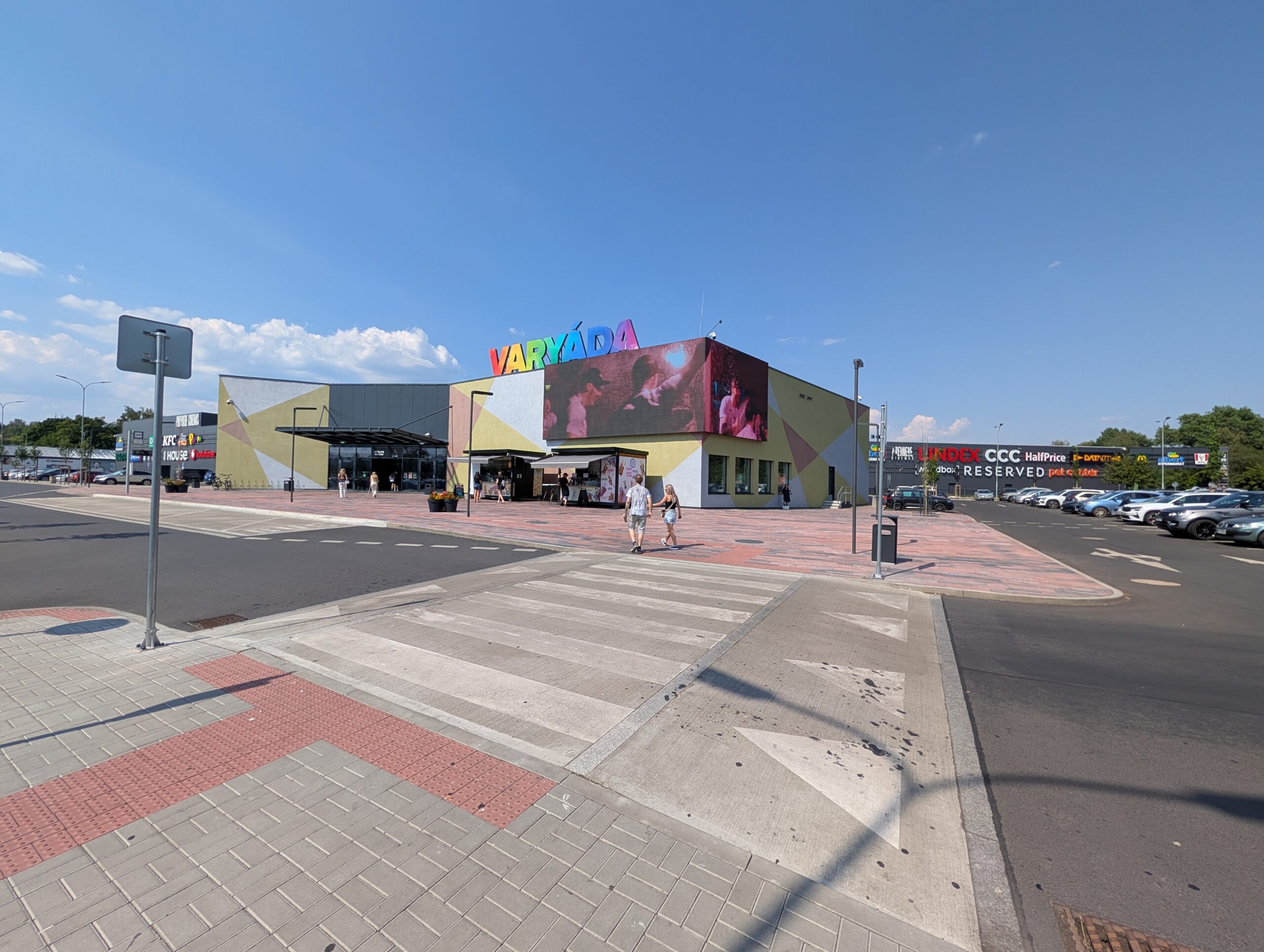 Haupteingang des Einkaufszentrums Varyáda (Obchodní centrum Varyáda) mit Parkplatz und modernem Eingangsbereich in Karlsbad.