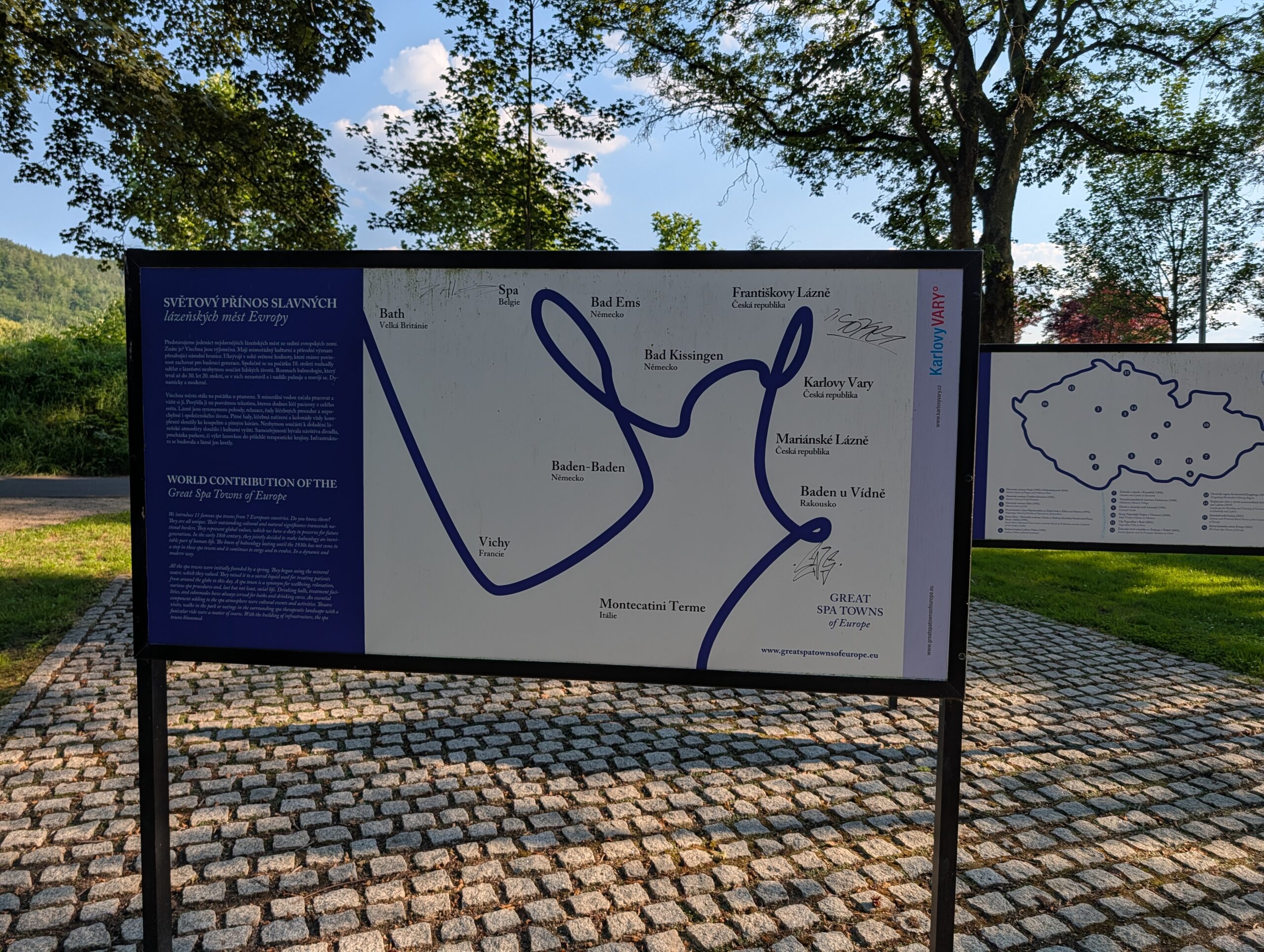 Informationstafel zum UNESCO-Welterbe der bedeutenden Kurstädte Europas an der Uferpromenade an der Eger (Náplavka Ohře) in Karlsbad.