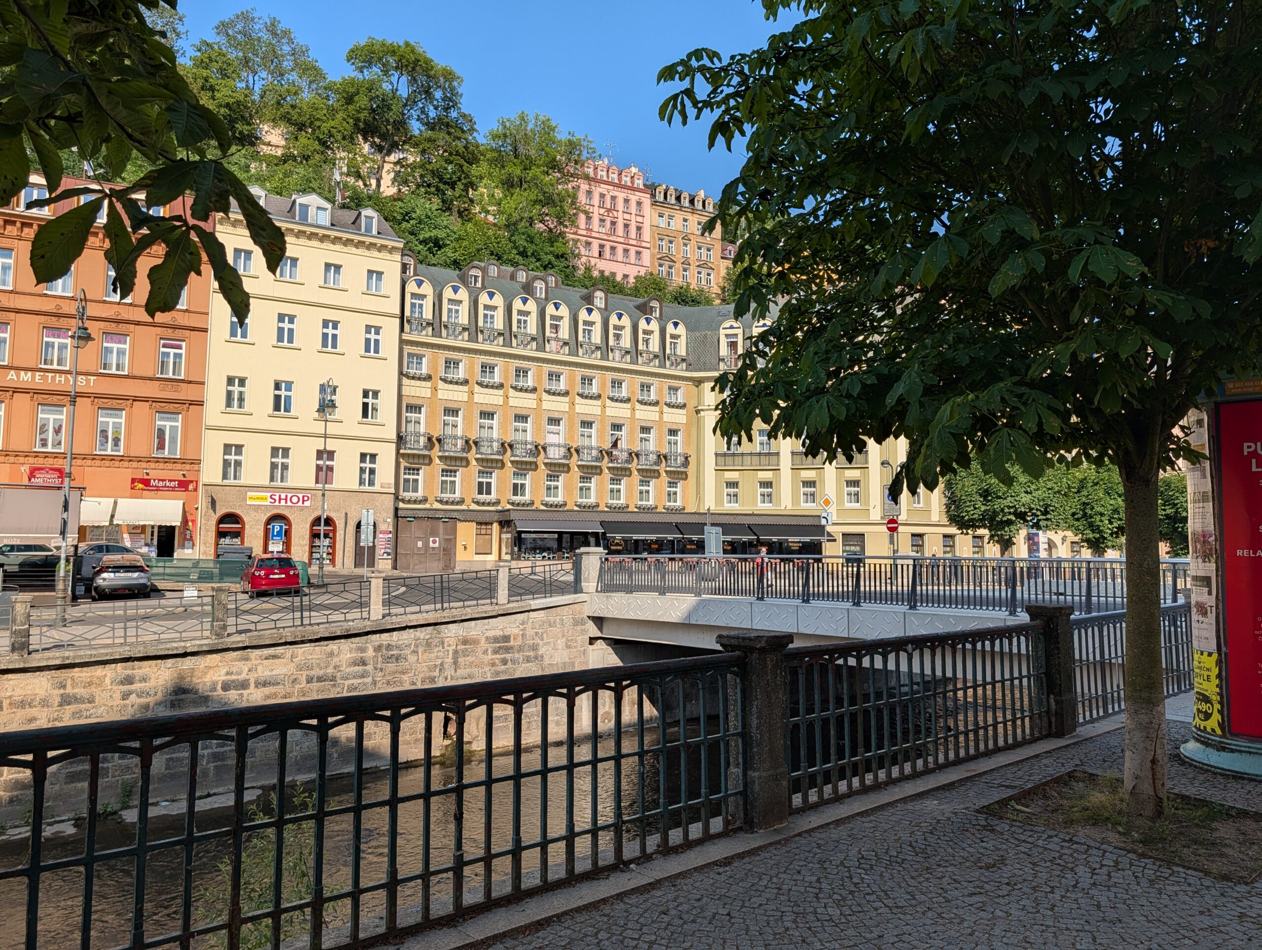 Kurbrücke (Lázeňský most) über die Teplá mit historischen Gebäuden im Kurviertel von Karlsbad.